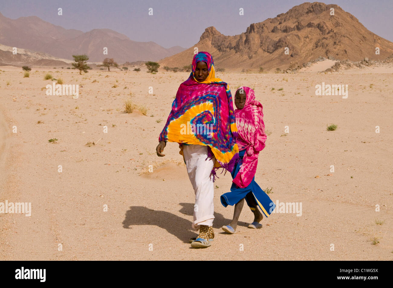 Algeria, Tasset, Tadrat, Mother walking with daughter through desert Stock Photo