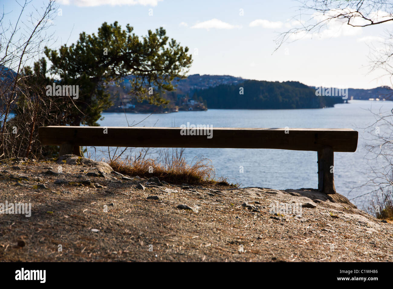 Picture of a lonely old wooden bench with view over the sea Stock Photo