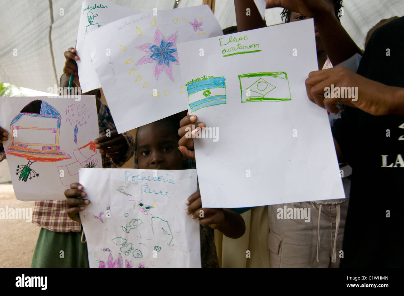 Orphans showing their drawing in a camp for survivors of a 7.0 magnitude earthquake which struck Haiti on 12 January 2010 in  the outskirts of Port-au-Prince Stock Photo