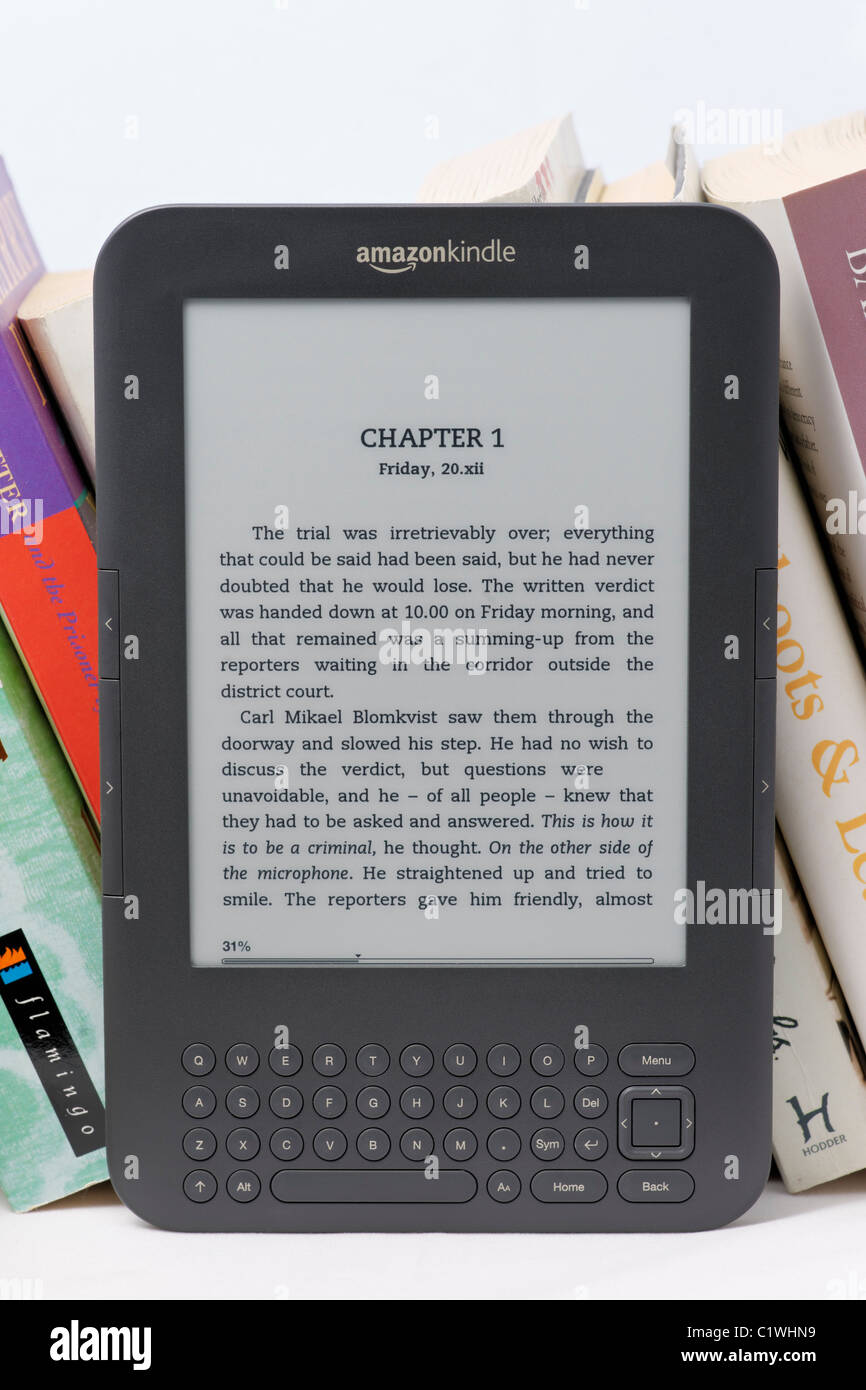 An Amazon Kindle Ebook Reader On A Bookshelf With Paperbacks This