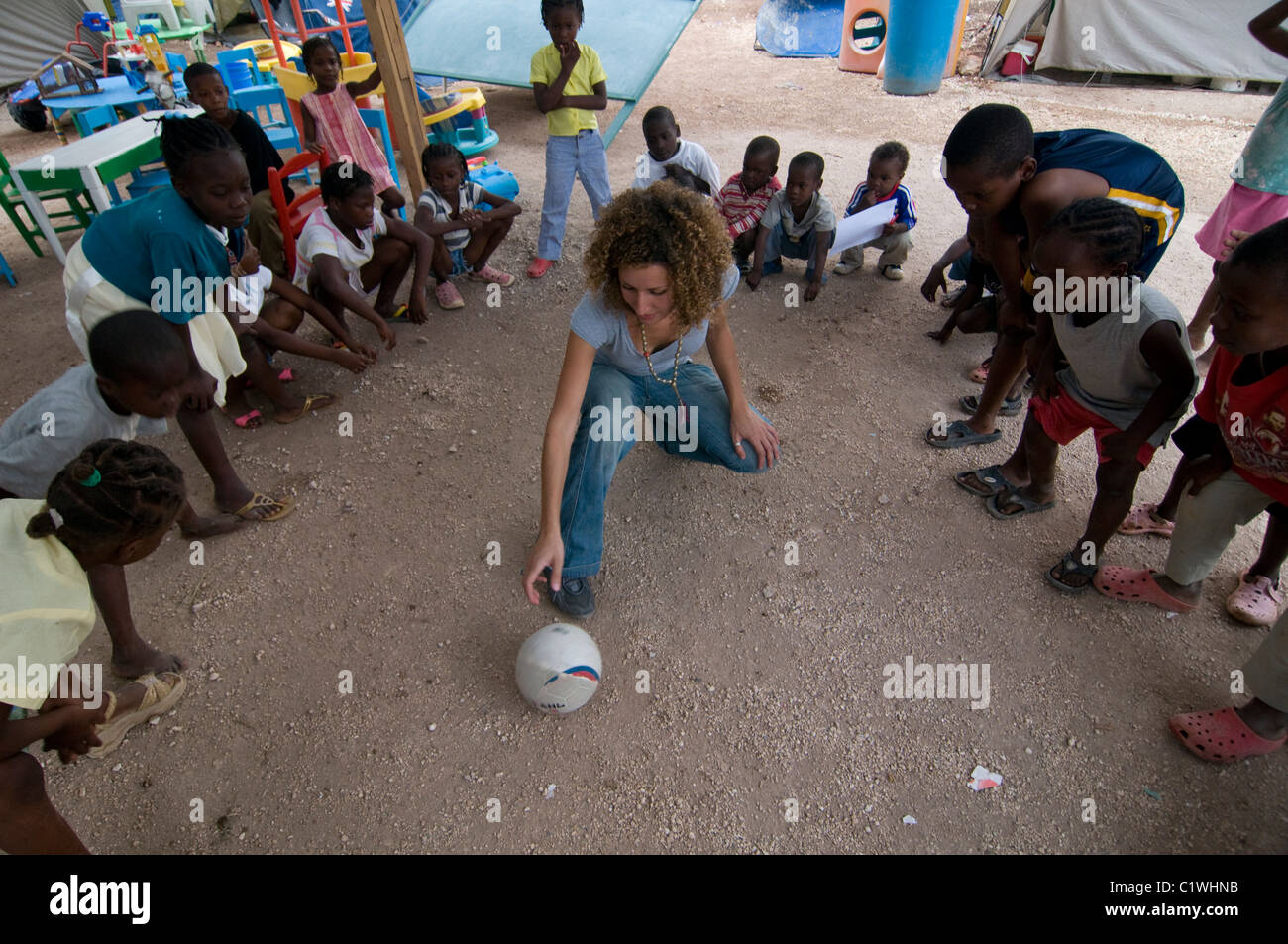 Noa Yaakov Israeli volunteer of Natan International Humanitarian Aid playing with young orphans in a makeshift camp for survivors of a 7.0 magnitude earthquake which struck Haiti on 12 January 2010 in  the outskirts of Port-au-Prince Stock Photo