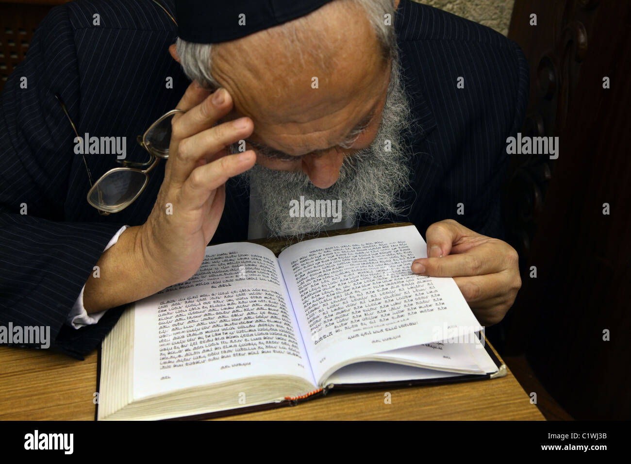 A religious Jew reads the Siddur Jewish book of pray in Israel Stock
