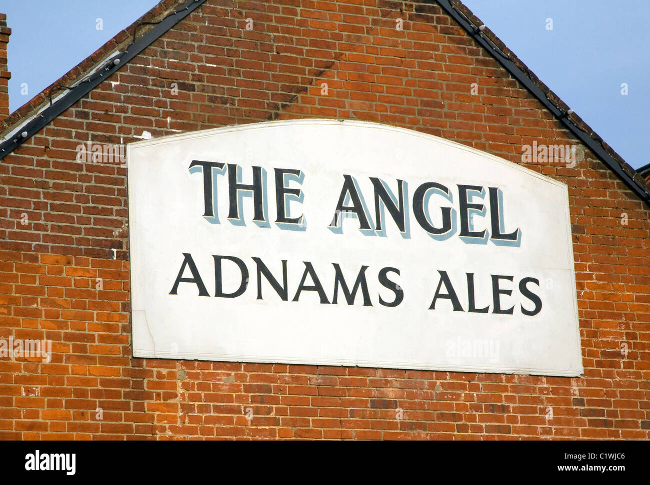 The Angel pub Adnams Ales sign brick wall building Halesworth Suffolk Stock Photo