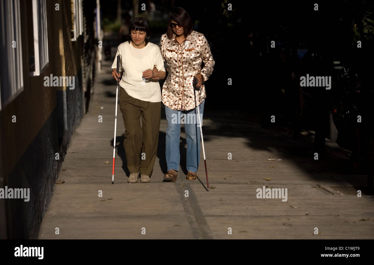 Blind photographers walk on the sidewalk using canes during a photography workshop for the blind and visually impaired Stock Photo