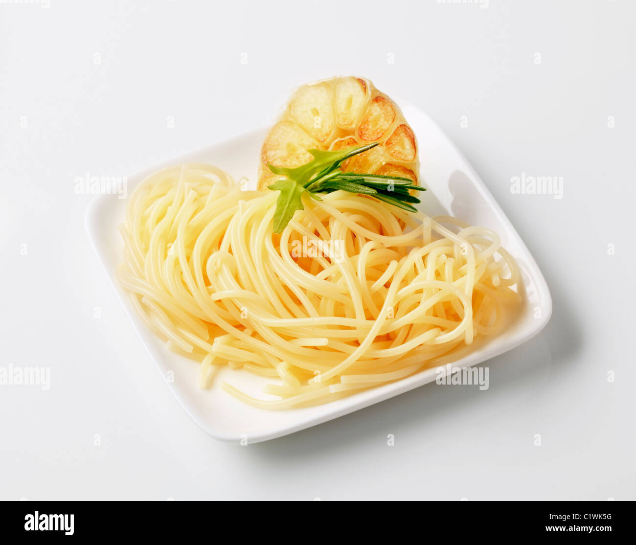 Cooked spaghetti and baked garlic - studio Stock Photo