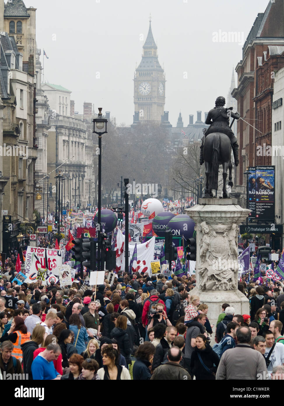 Protesters march down Whitehall as they take part in a demonstration against Government cuts in London. Stock Photo