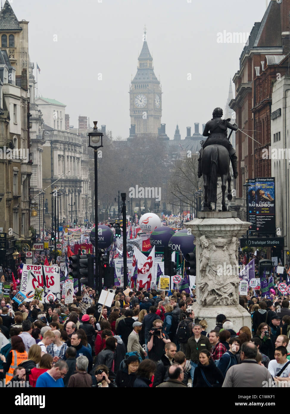 Protesters march down Whitehall as they take part in a demonstration against Government cuts in London. Stock Photo