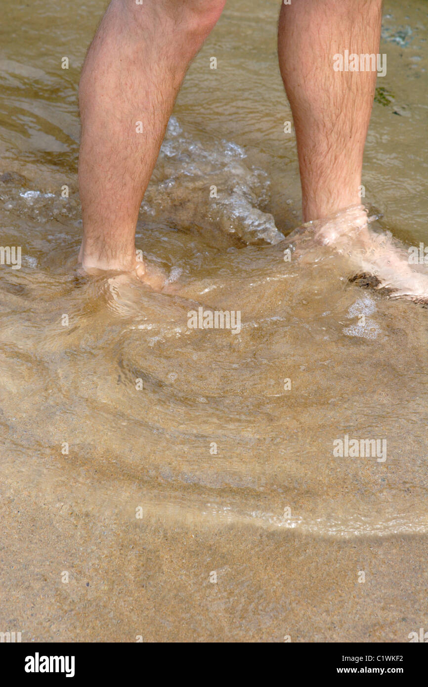 Man paddling in sea water at beach Stock Photo