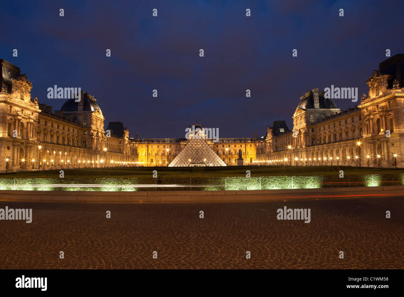The Louvre museum at night (Musée du Louvre) showing pyramid within the Cour Napoléon. Stock Photo