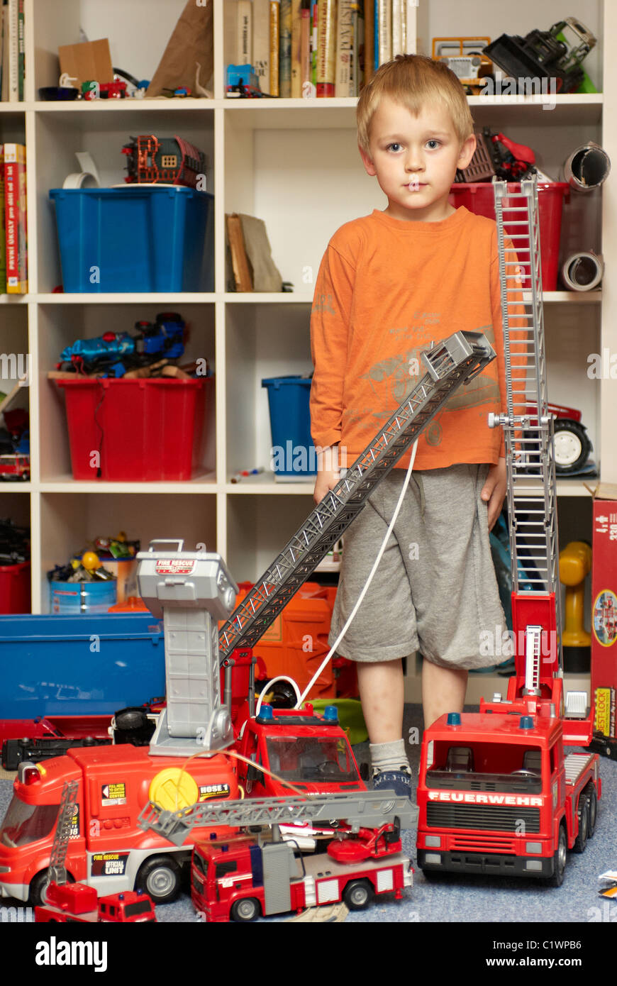 Young boy playing with toy fire truck in children´s room Stock Photo