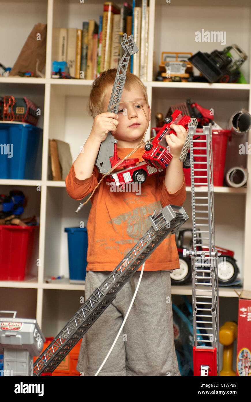 Young boy playing with toy fire truck in children´s room Stock Photo