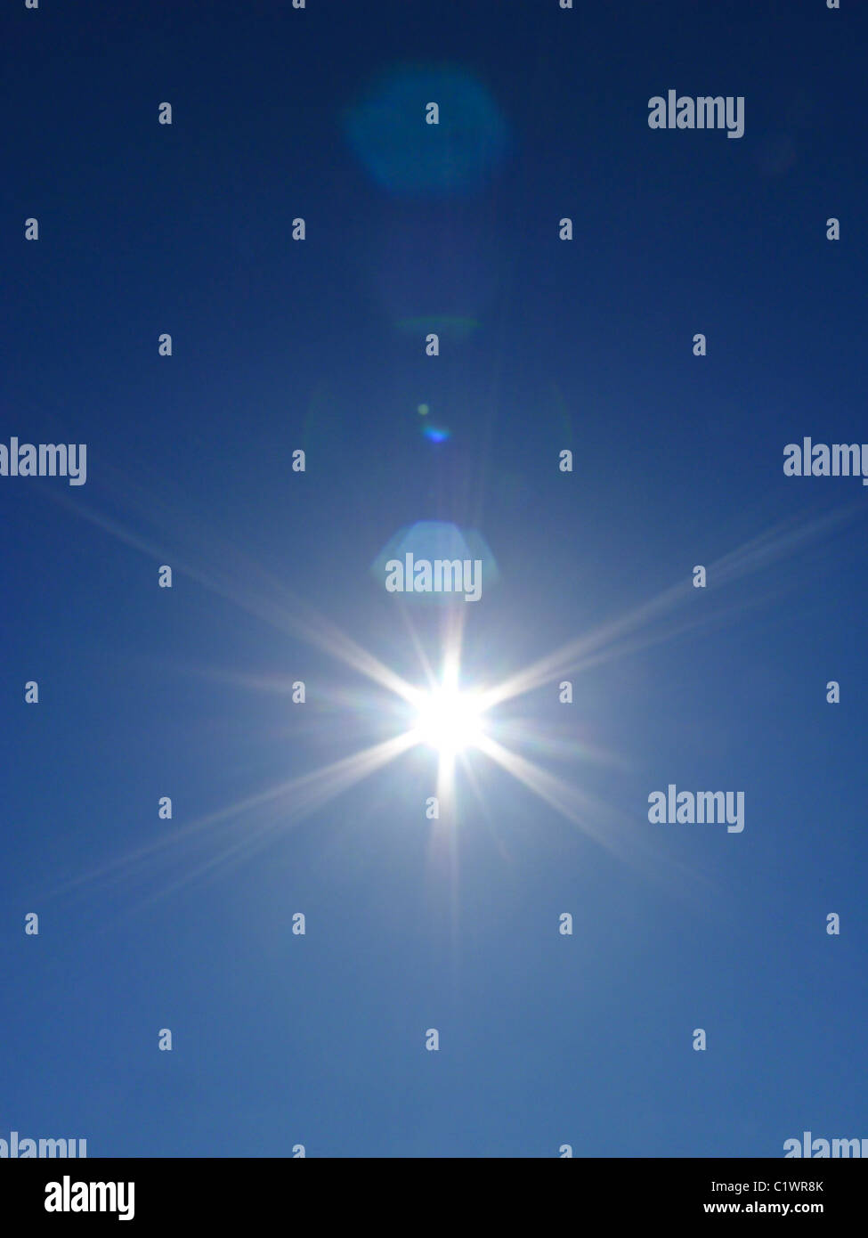 Bright inspirational sunburst in blue sky. Stock Photo