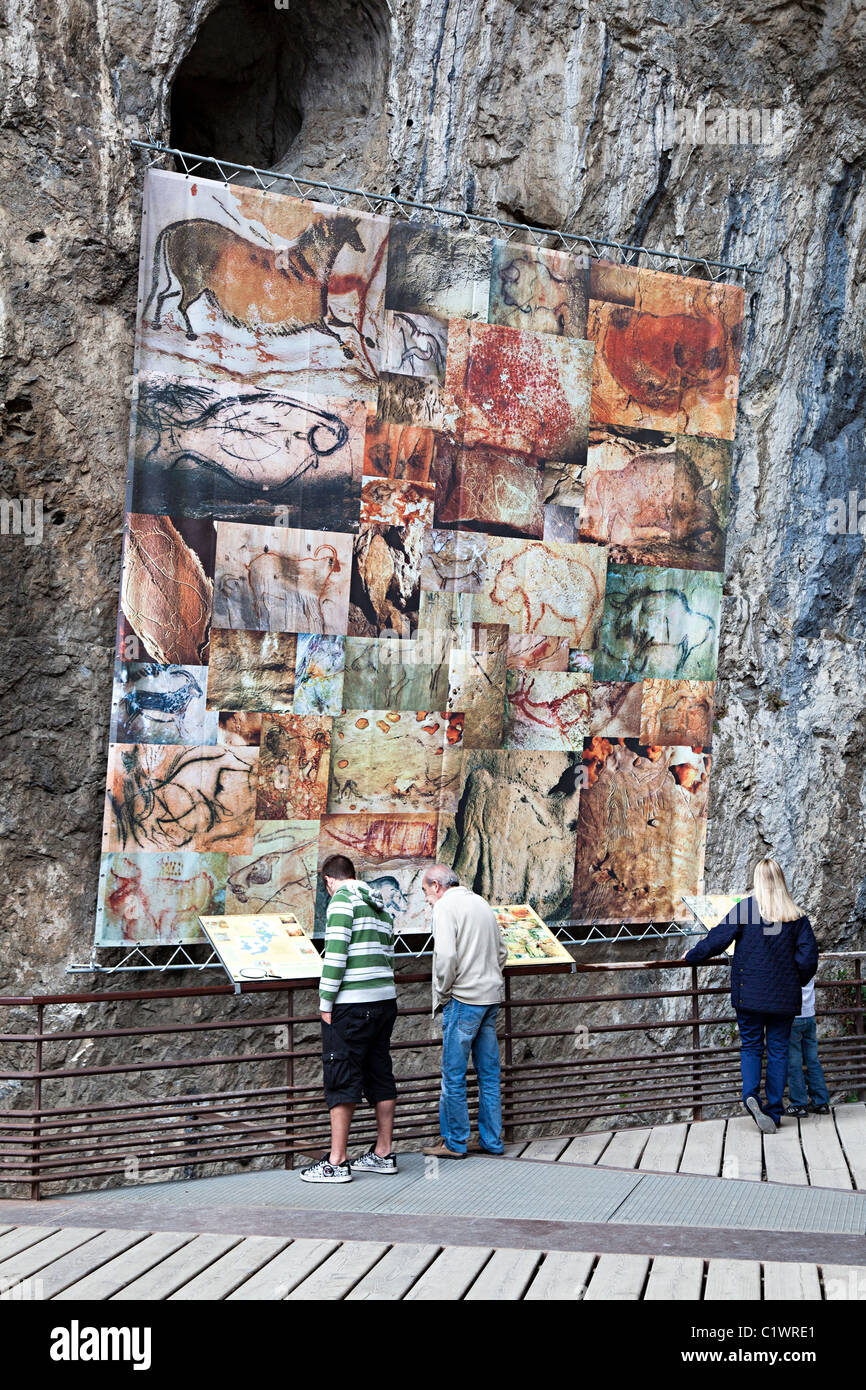 People reading information signs about prehistoric cave art Grotte de Niaux department Ariege France Stock Photo