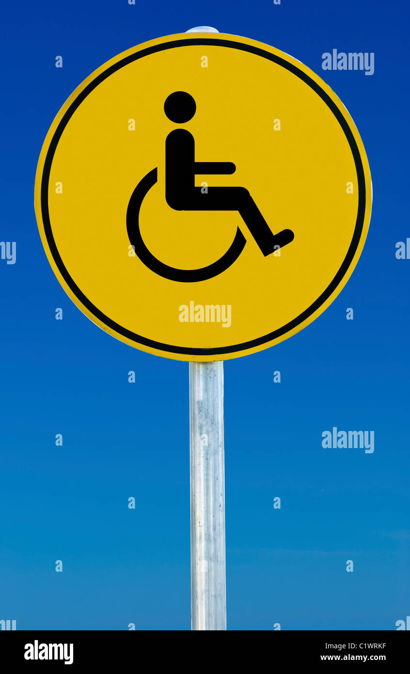 Wheelchair picture on a yellow sign isolated on a blue graduated sky. Stock Photo