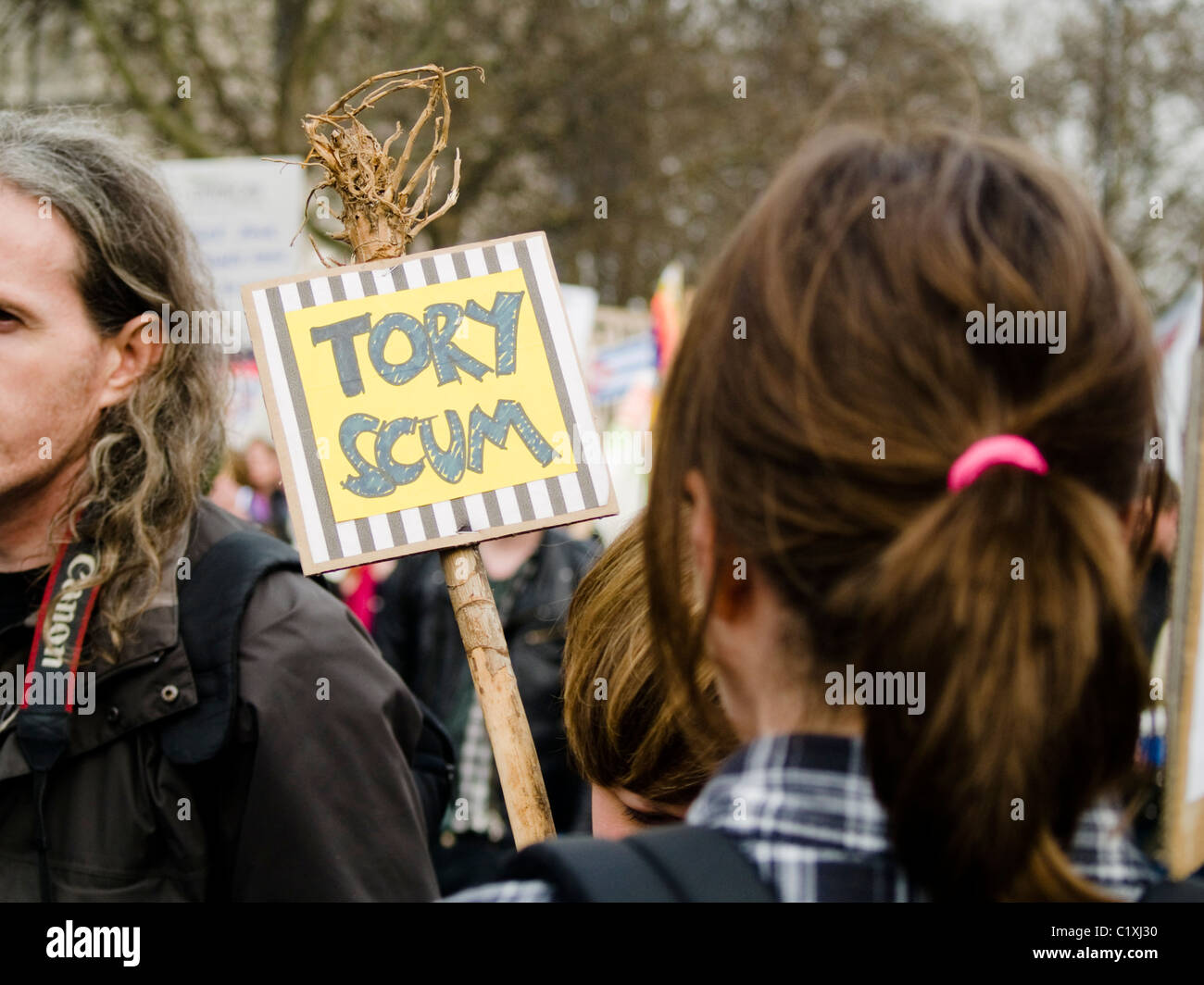 A protester holds up an anti Conservative Party sign at a TUC organised march against Government cuts on 26 March 2011 Stock Photo