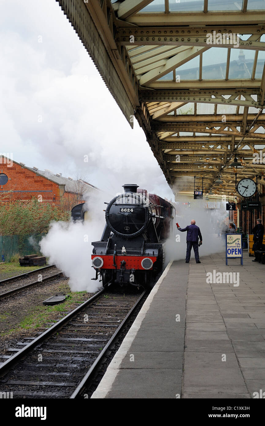 LMS Stanier 8F 2-8-0 locomotive 8624 passing through great central railway loughborough station working a morning train Stock Photo