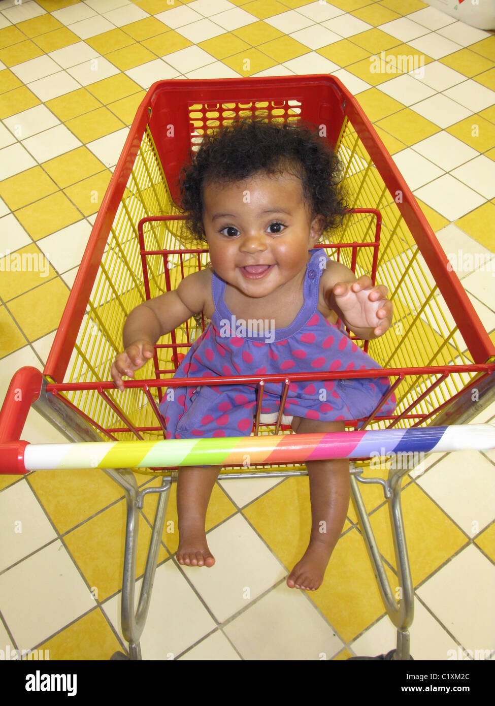 Infant sitting in a shopping cart Stock Photo