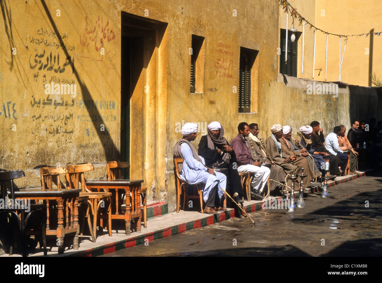 Men smoking waterpipes and drinking coffee outside cafe, Luxor, Egypt Stock Photo