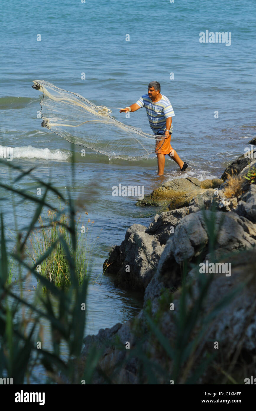 Man throwing a fishing net in the mouth of the river flowing Aegean Sea.  Sarigerme, Mediterranean, TURKEY Stock Photo - Alamy