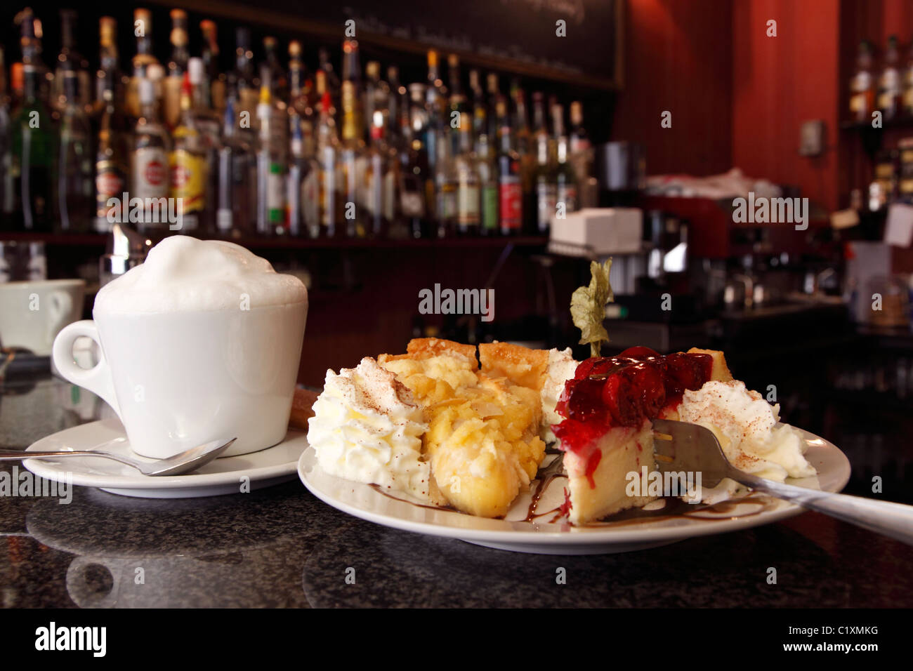 apple and cherry pie and a cappuccino on the counter of a German coffee bar Stock Photo