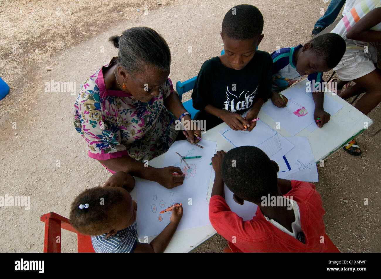 Orphans drawing in a makeshift camp for survivors of a 7.0 magnitude earthquake which struck Haiti on 12 January 2010 in  the outskirts of Port-au-Prince Stock Photo