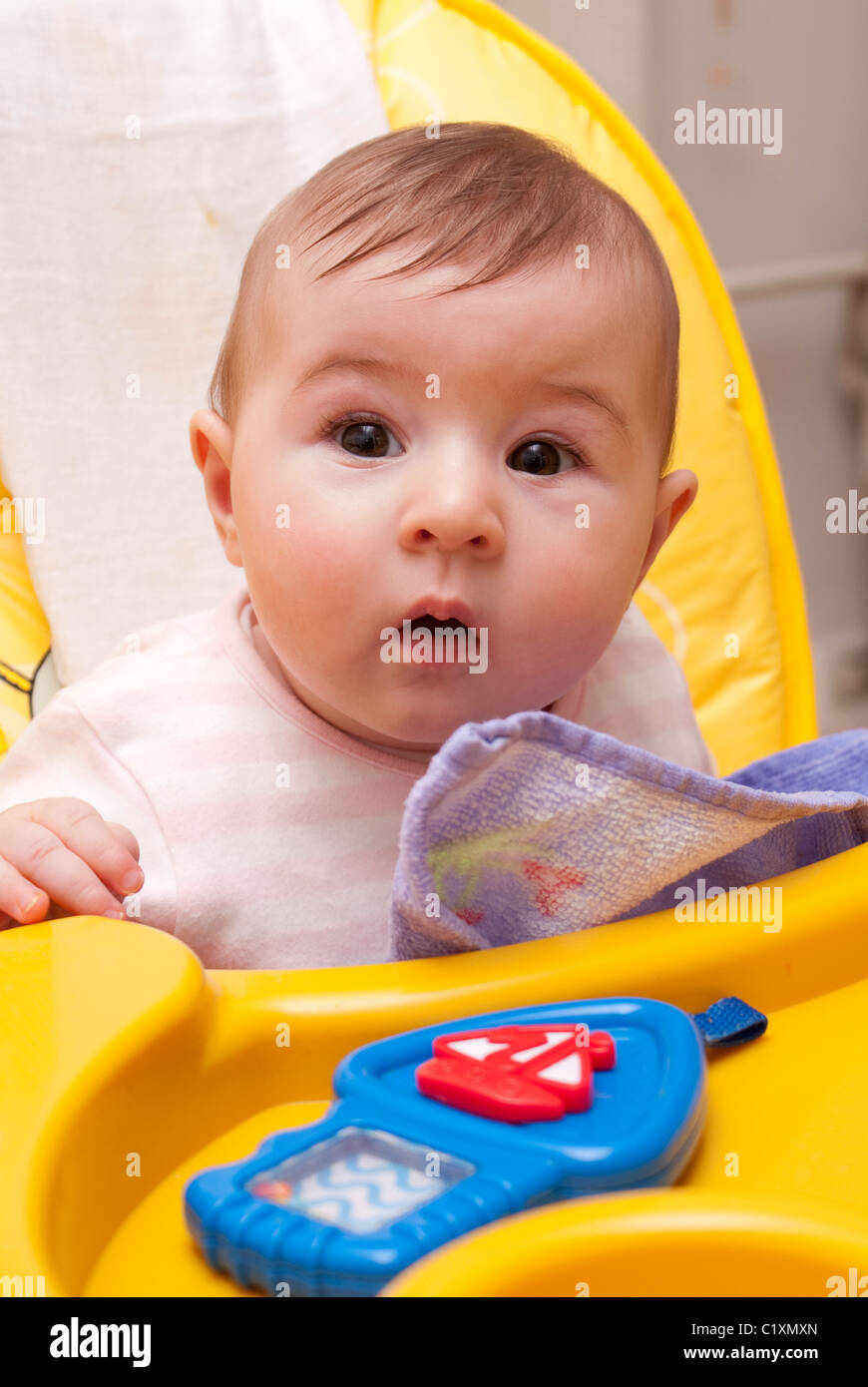 Baby in high chair looking surprised Stock Photo Alamy