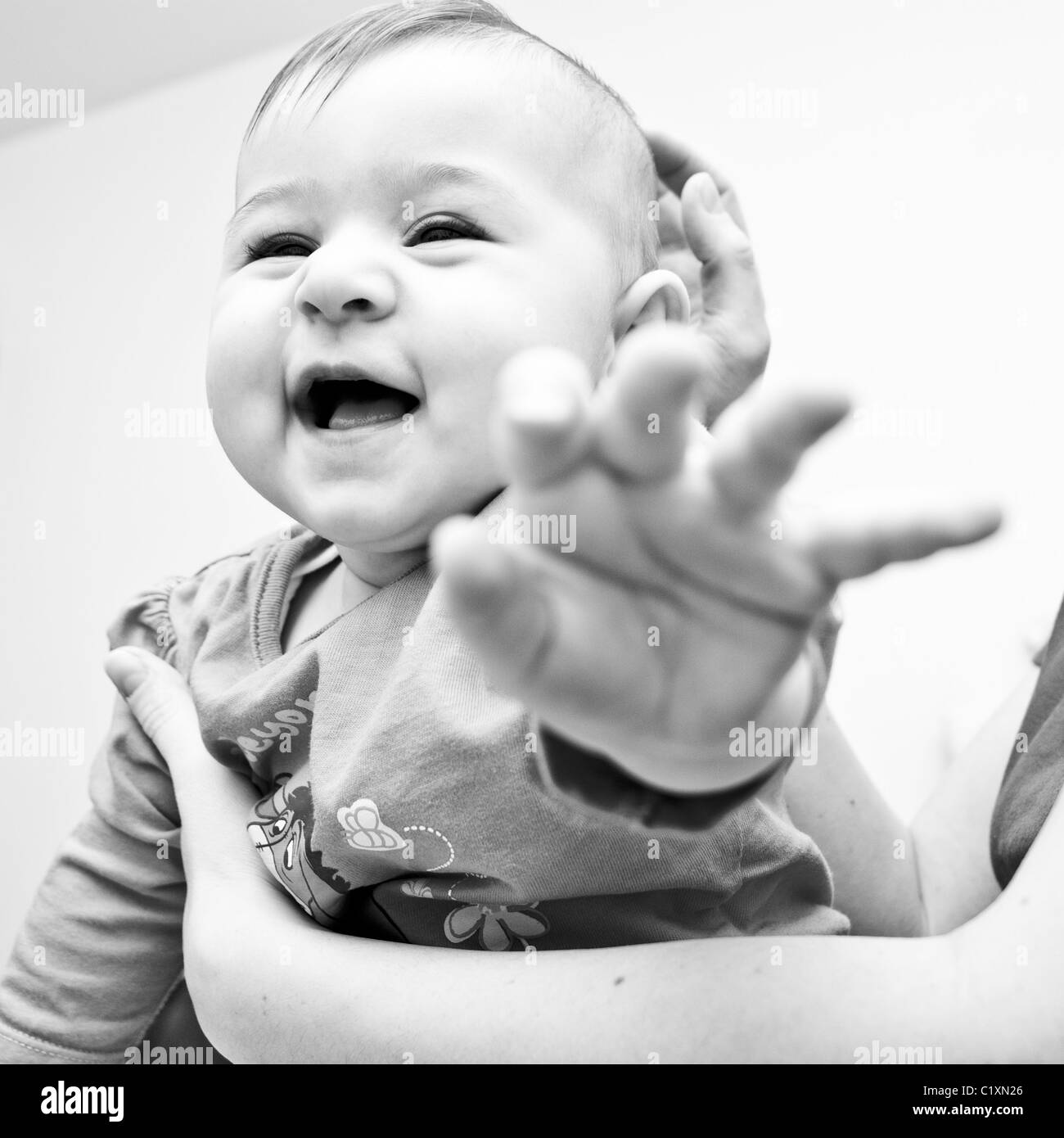 Baby laughing and reaching for camera Stock Photo