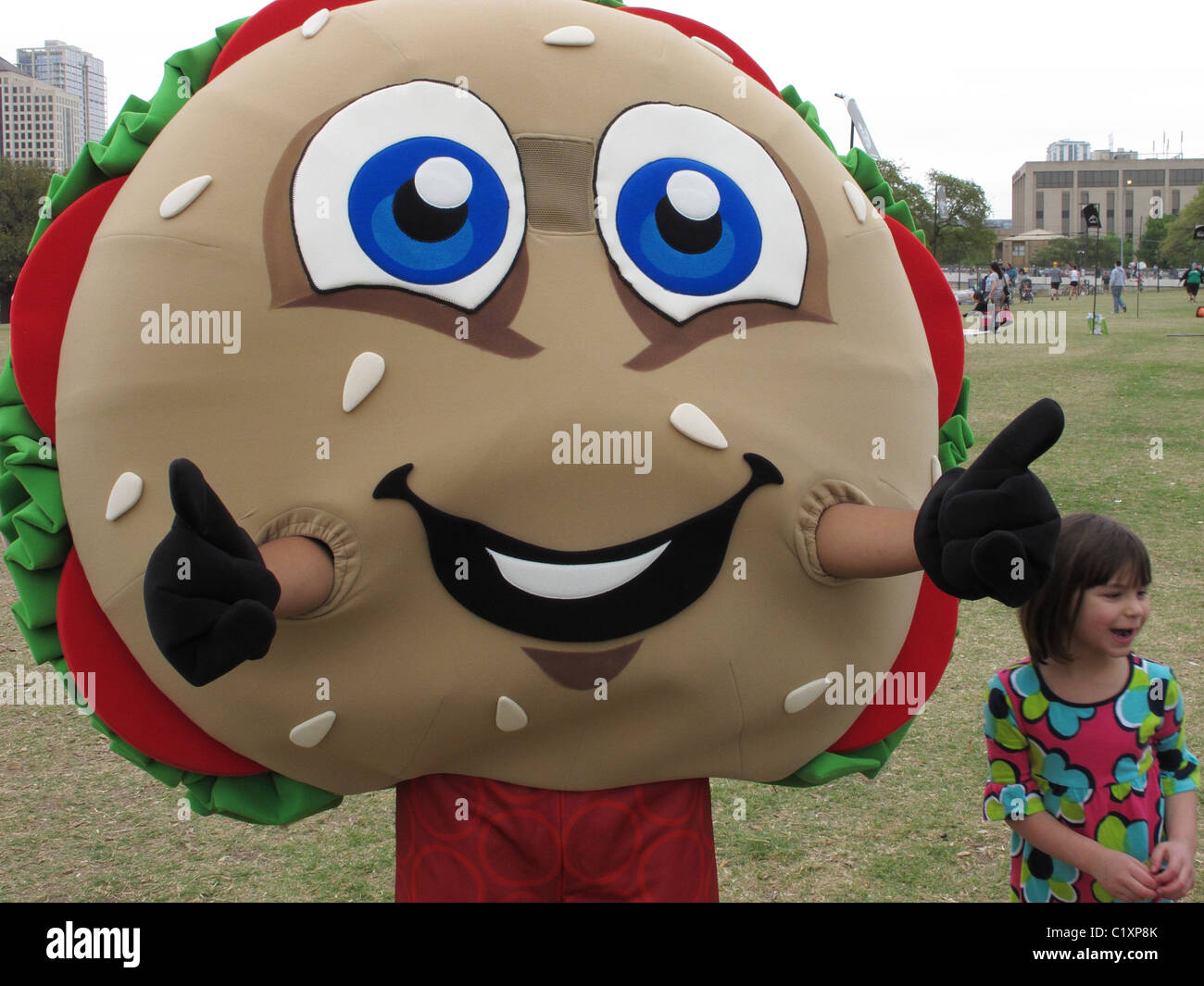 H.E. Buddy, the HEB Mascot at Cap 10k in Austin, Texas and little girl Stock Photo