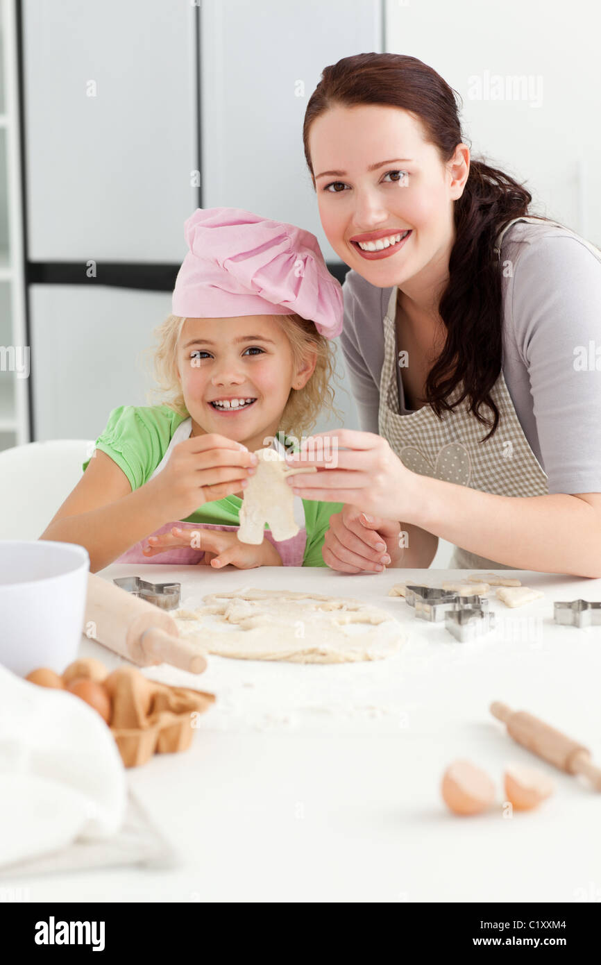 Happy girl with her mother baking little cakes Stock Photo