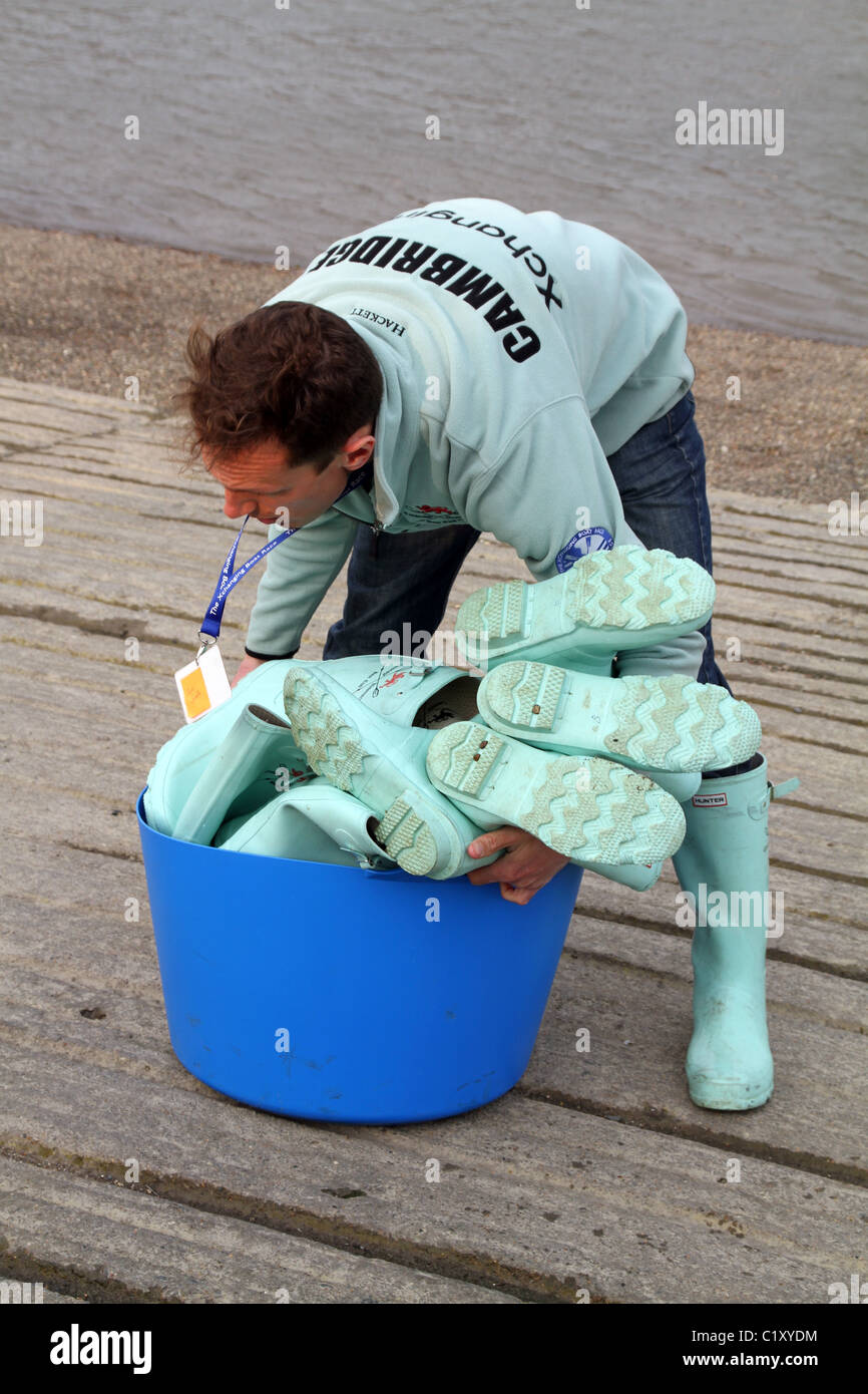 UK CAMBRIDGE STUDENT HELPING AT THE OXFORD VS CAMBRIDGE BOAT RACE ON THAMES RIVER Stock Photo 