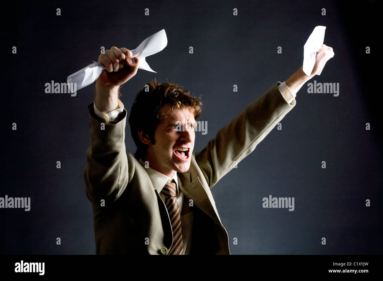 Photo of emotional businessman with papers raising his arms Stock Photo ...