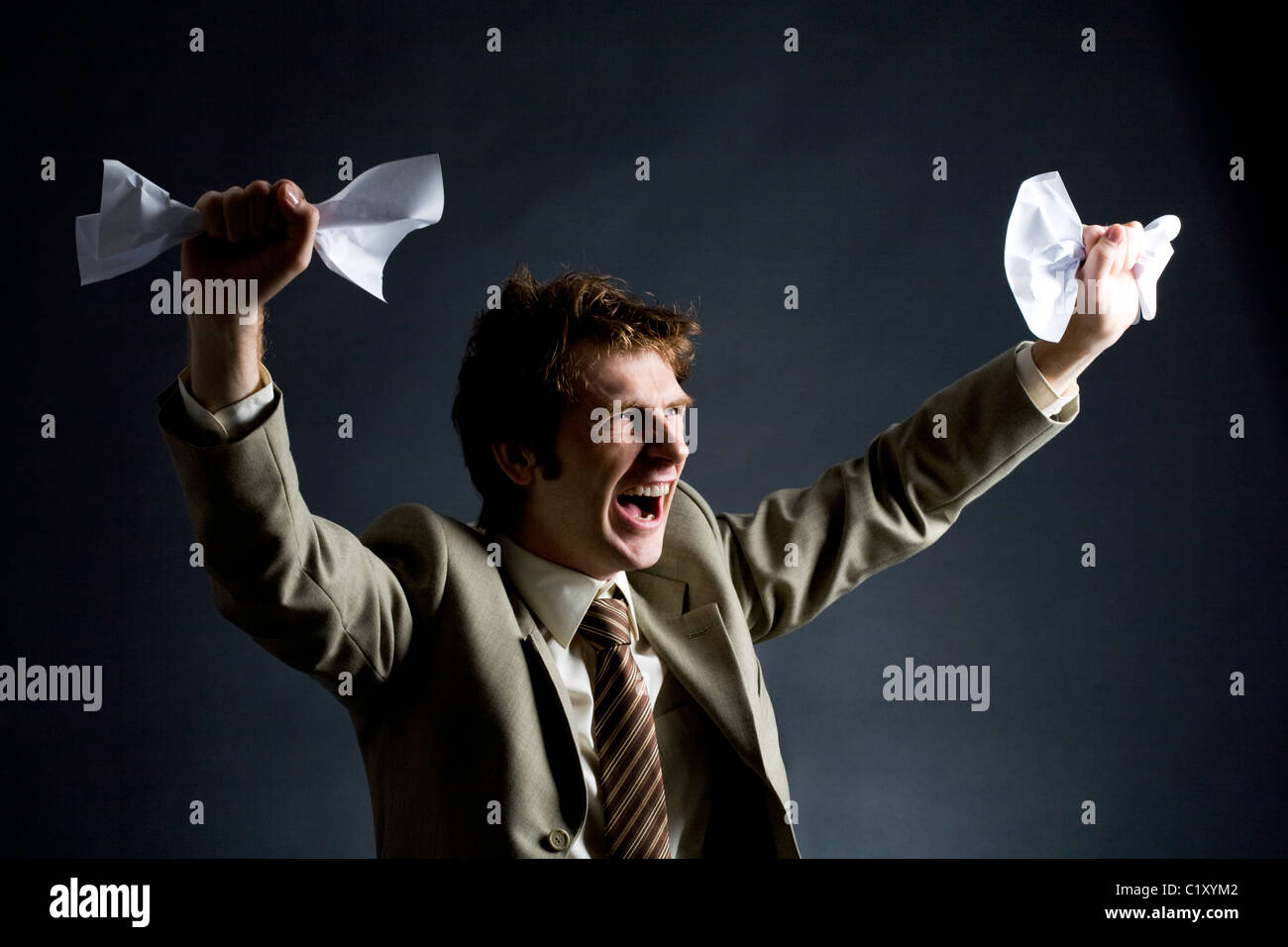 Photo of emotional businessman with papers raising his arms Stock Photo ...