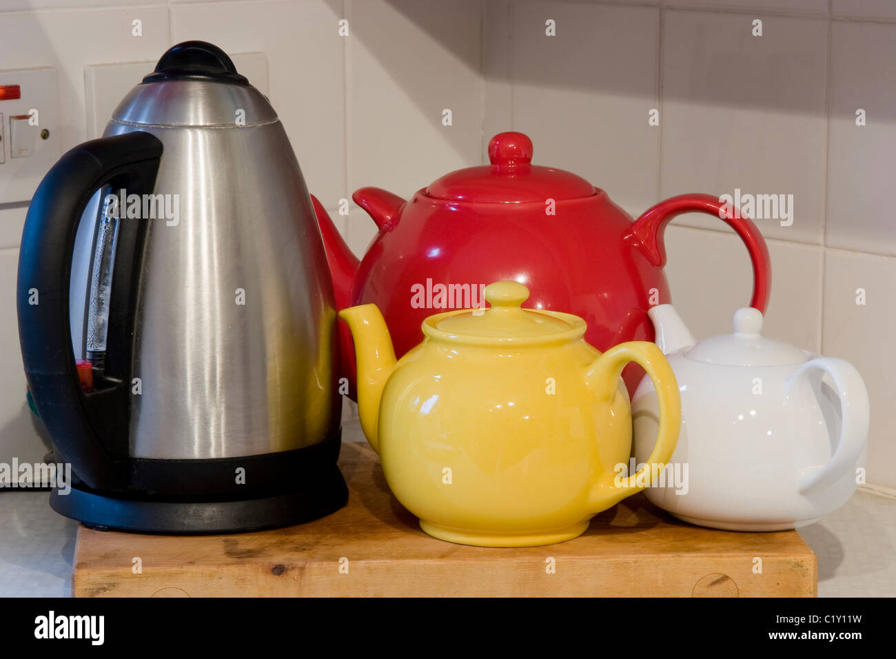 Three teapots and a metal electric kettle Stock Photo Alamy