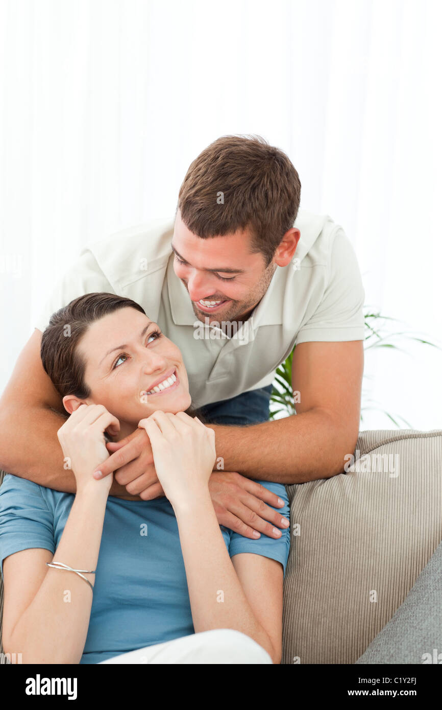 Affectionate man talking with his girlfriend sitting on the sofa Stock Photo