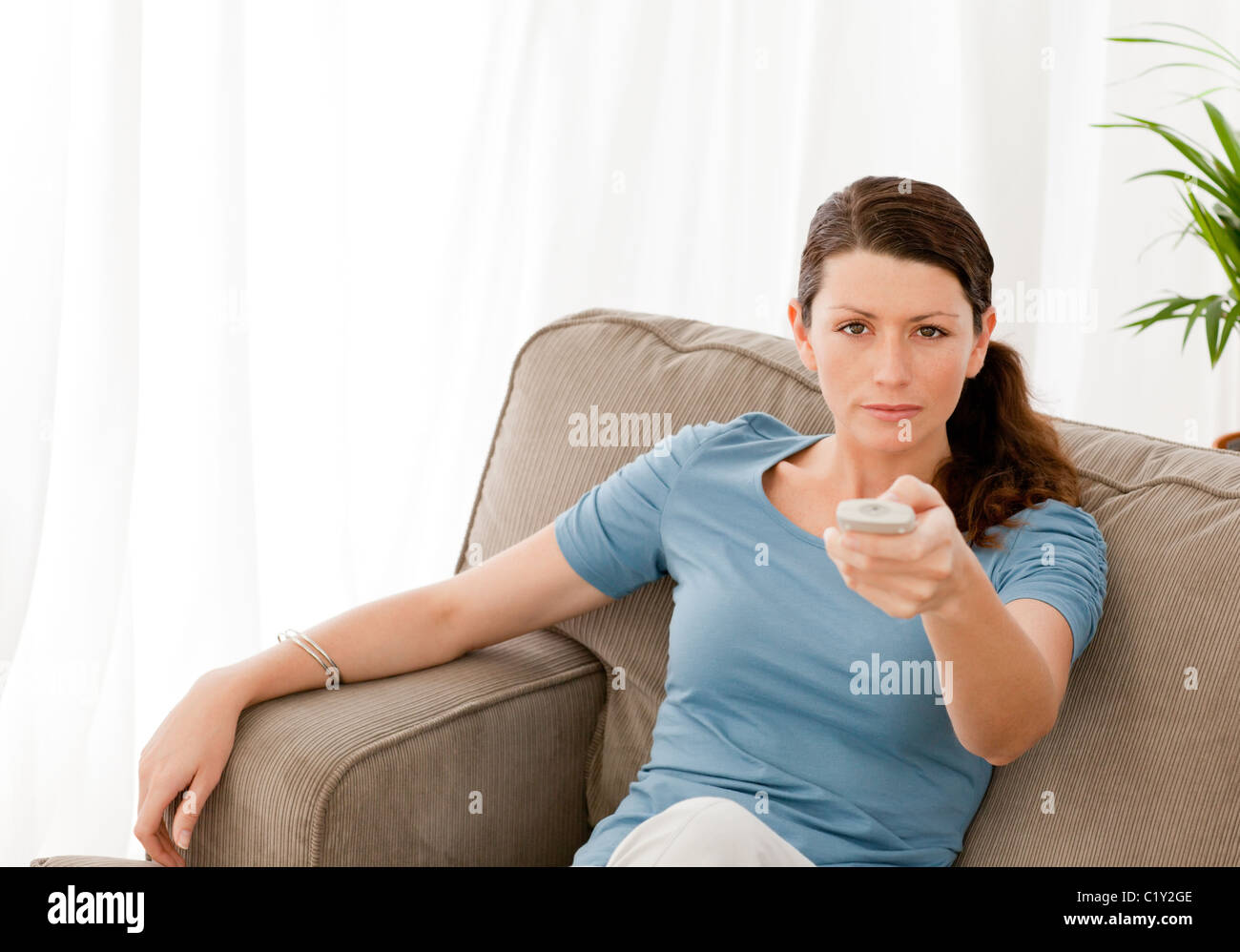 Charismatic woman watching television at home Stock Photo