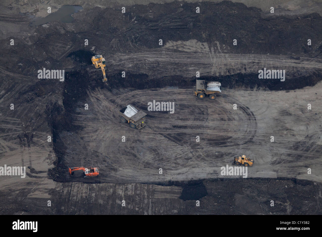 Aerial view of excavators excavating black surface mine, Athabasca Oil Sands, Fort McMurray, Canada Stock Photo