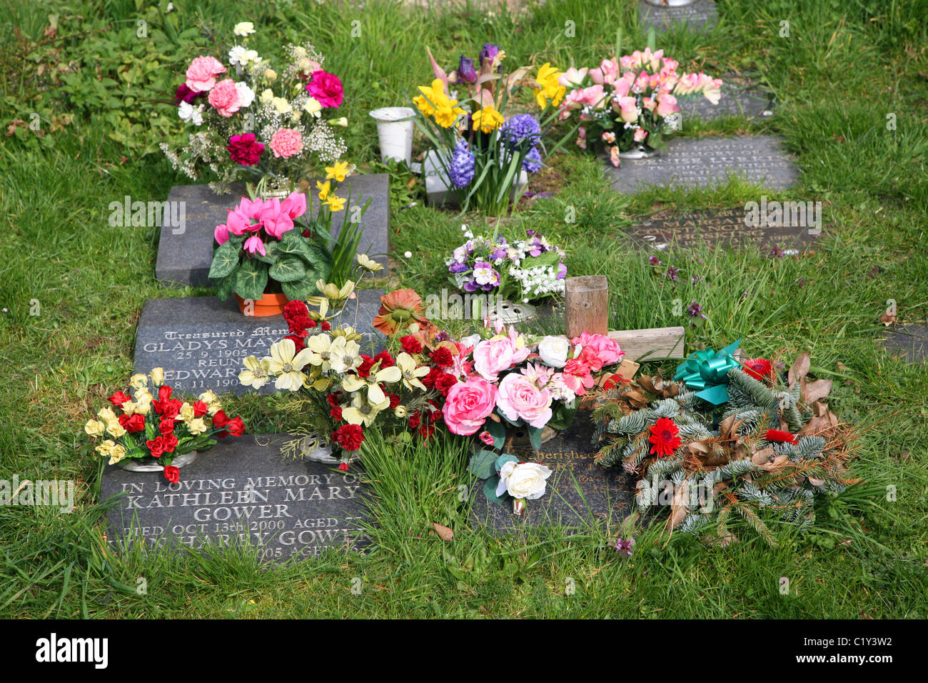 Flowers on memorial stones in graveyard Stock Photo