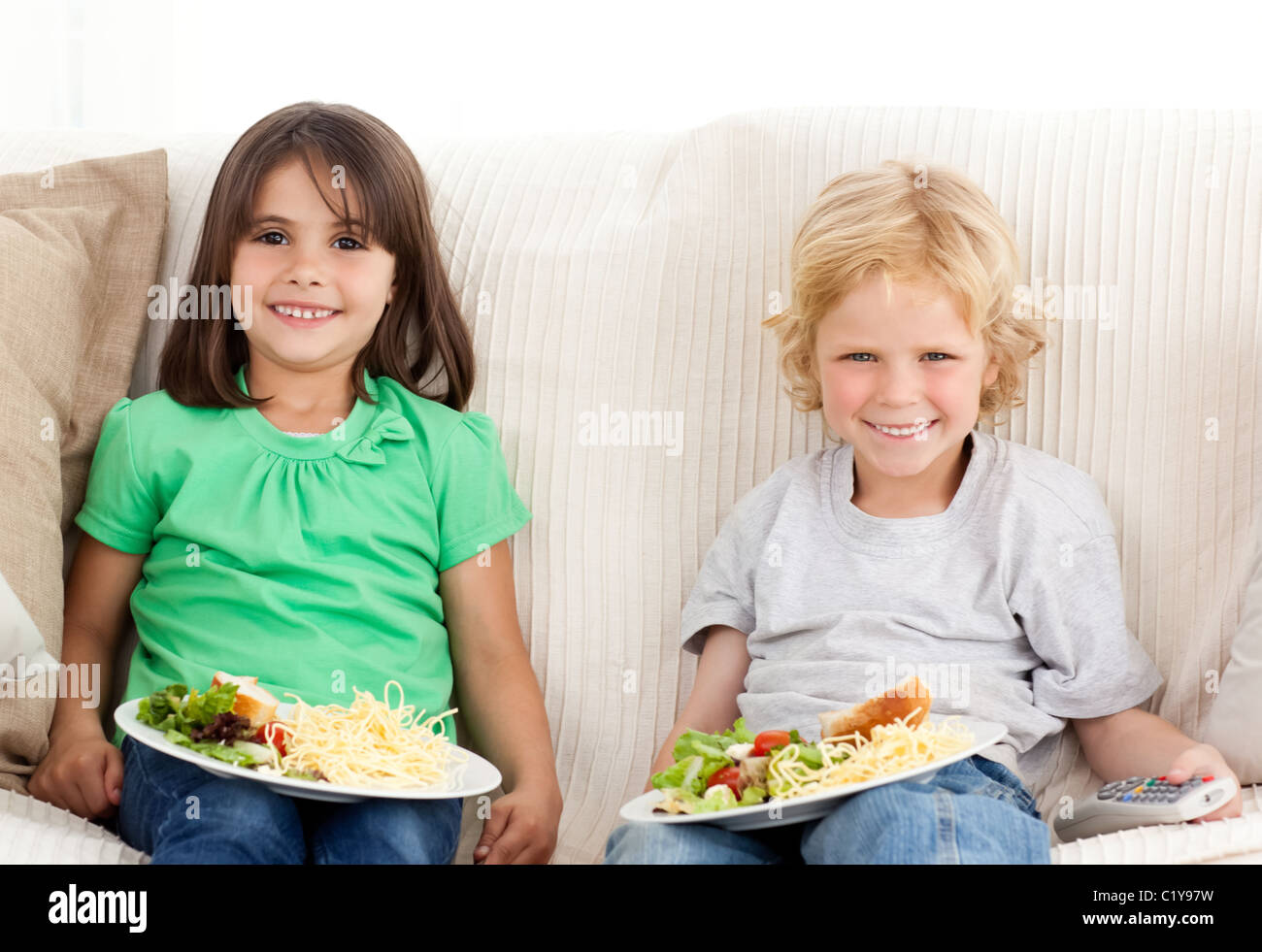 Happy brother and sister having TV dinner Stock Photo Alamy