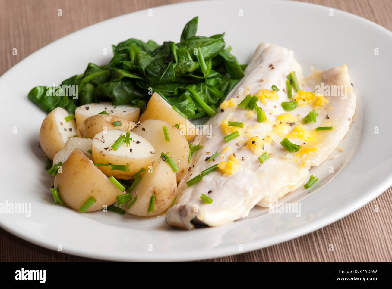 Sea bass with new potatoes and spinach Stock Photo Alamy