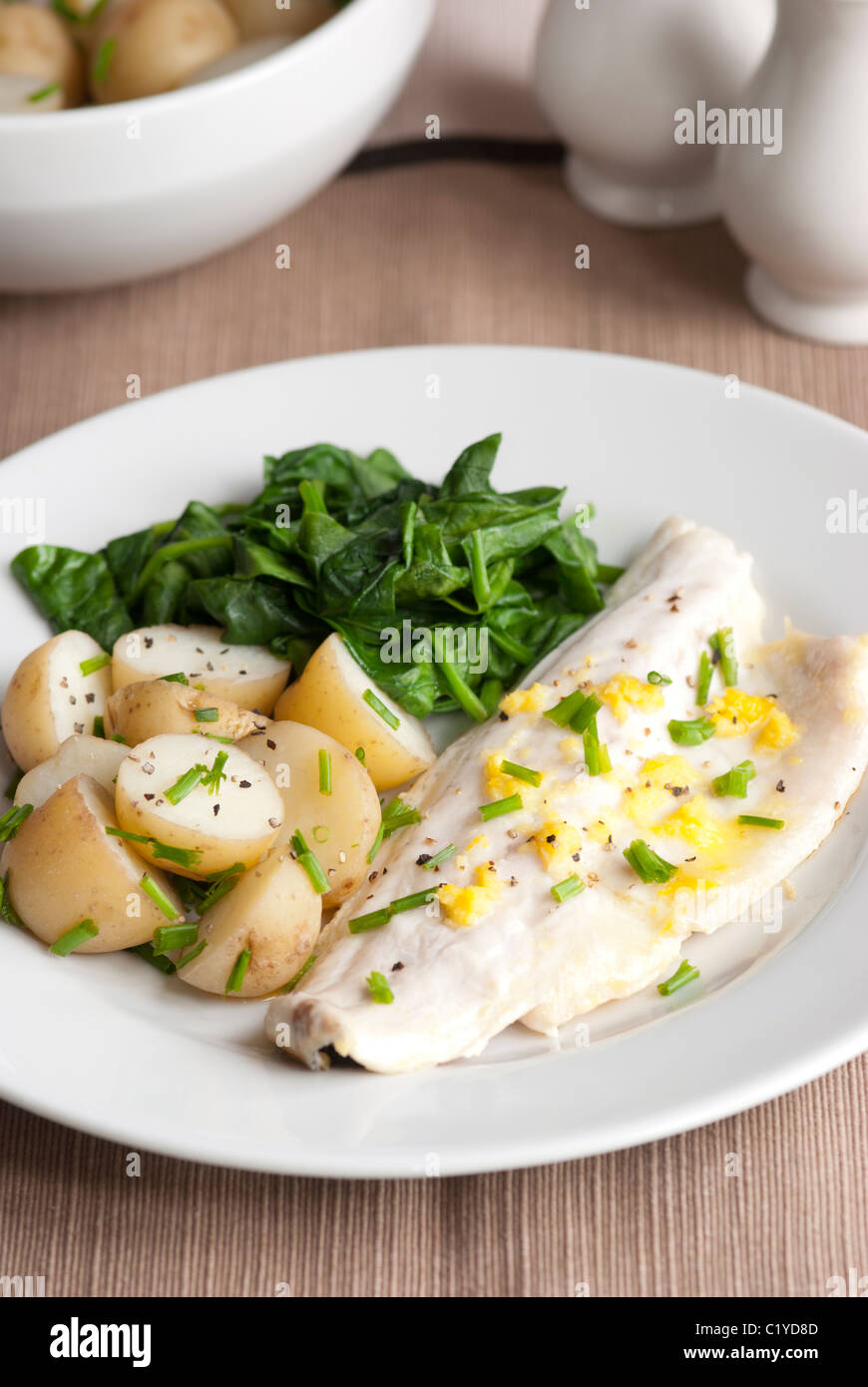 Sea bass with new potatoes and spinach Stock Photo Alamy