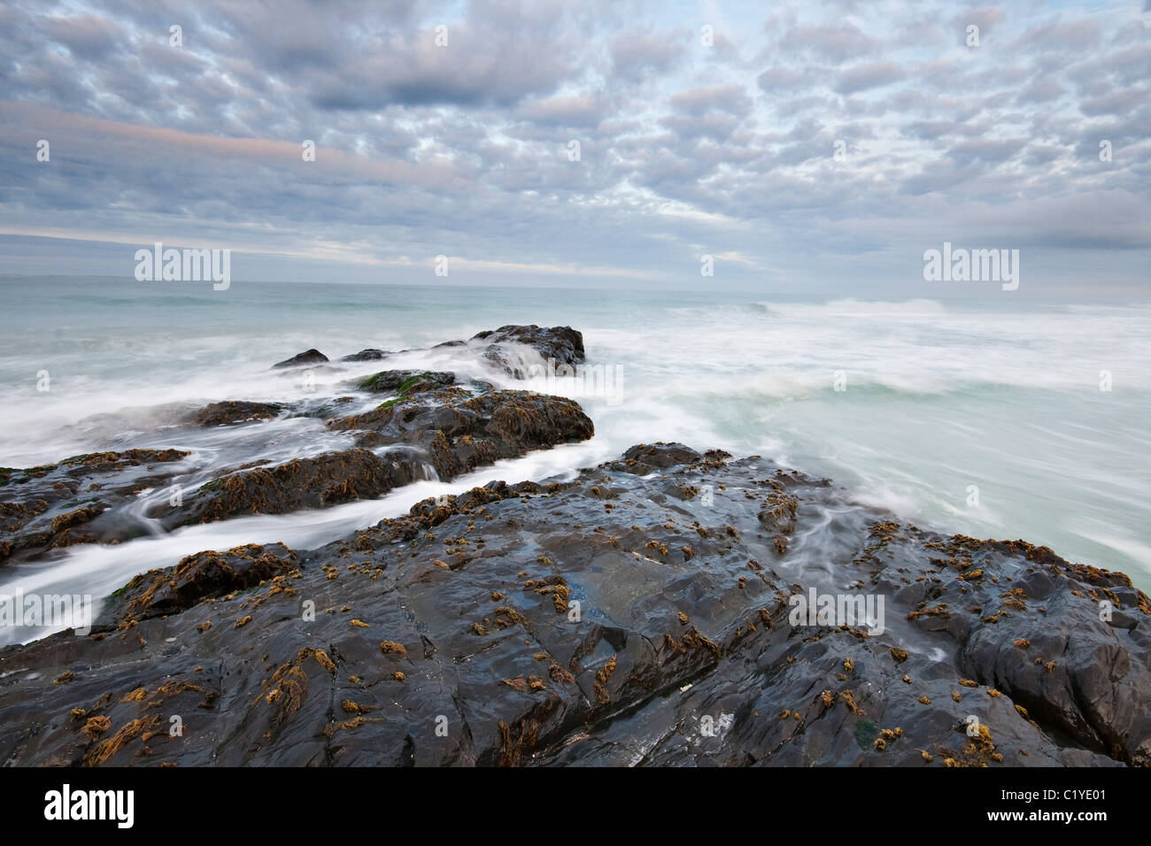 Waves breaking over rocks in the early morning Stock Photo - Alamy