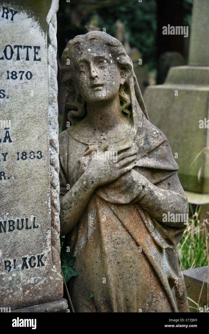 Statue of a woman in mourning by a headstone in a cemetery in Edinburgh, Scotland, UK. Stock Photo