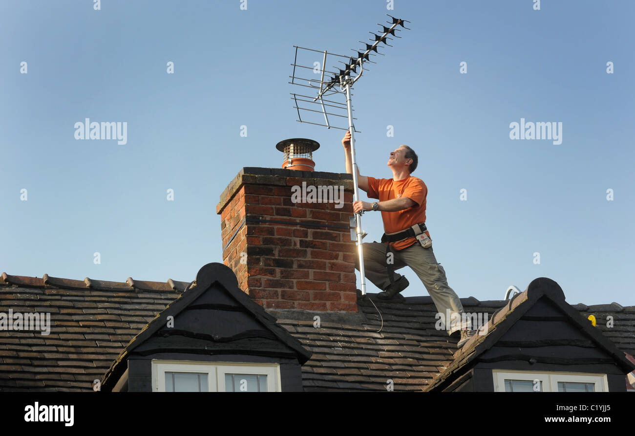 AERIAL FITTER FITTING NEW DIGITAL  TV AERIAL TO DOMESTIC HOUSE RE DIGITAL SWITCHOVER NEW AERIALS SIGNAL ANALOGUE SWITCH OFF UK Stock Photo