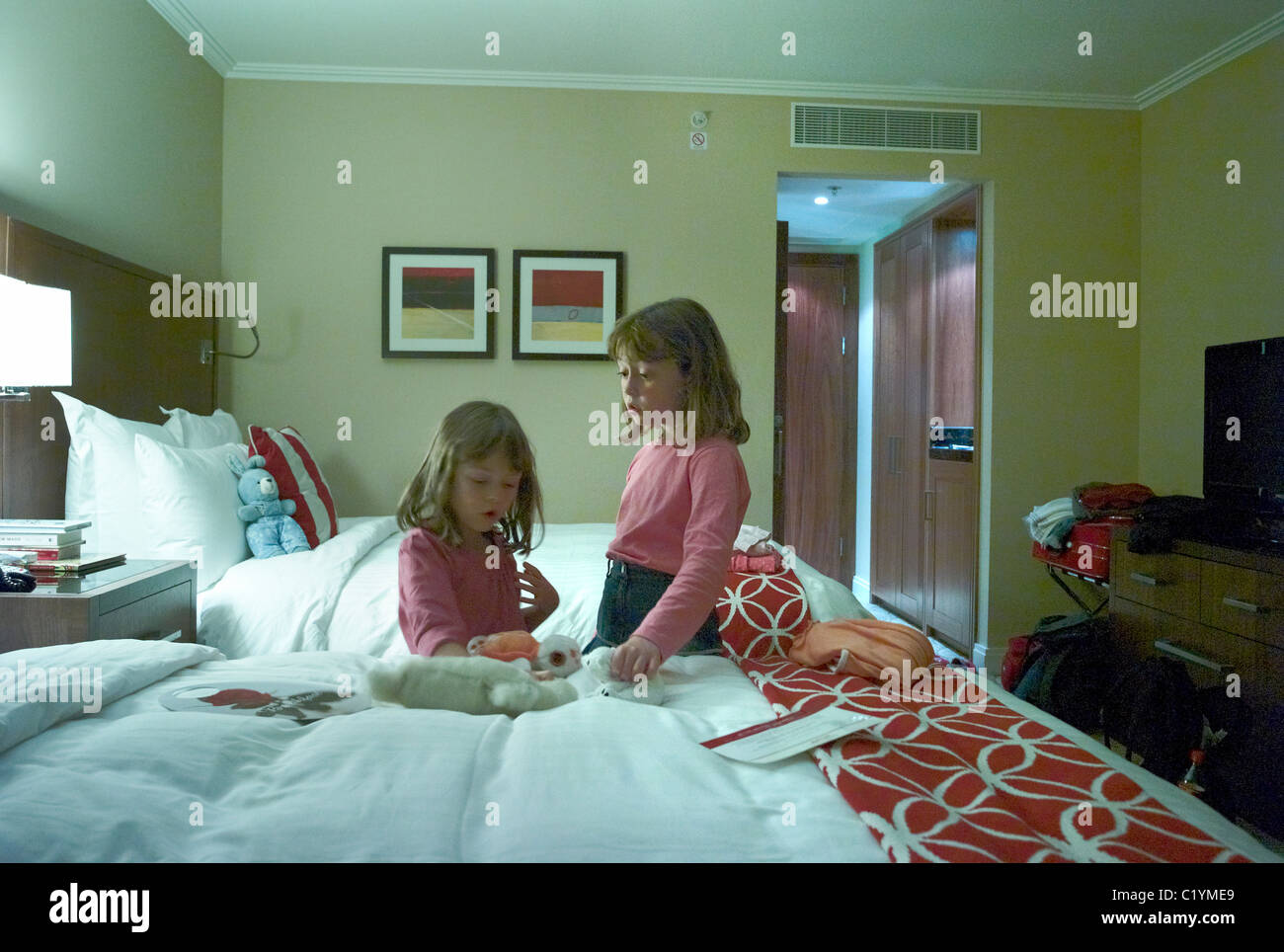 Two young children alone in a hotel room Stock Photo