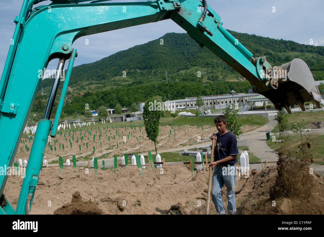 Man digging new graves at Srebrenica Potocari Genocide memorial and cemetery for the victims of the 1995 Genocide in Republika Srpska an entity of Bosnia and Herzegovina. More than 8,000 Bosnian Muslim men and boys were killed after the Bosnian Serb Army attacked Srebrenica, a designated UN safe area, on 10-11 July 1995, despite the presence of UN peacekeepers. Stock Photo