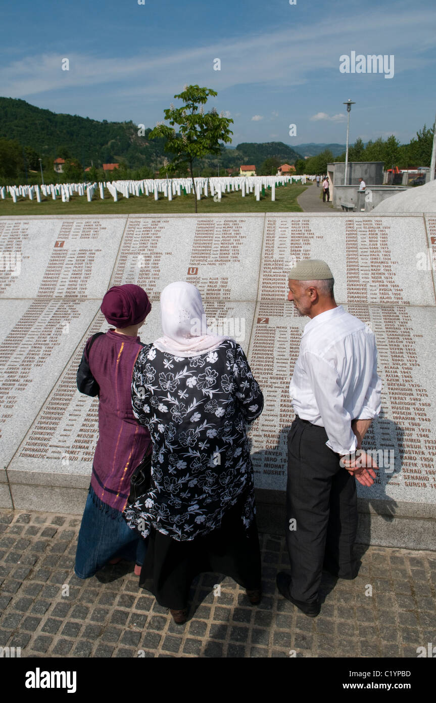 Bosniaks reading wall of names at Srebrenica Potocari Genocide memorial and cemetery for victims of 1995 Genocide in the easternmost part of Republika Srpska, an entity of Bosnia and Herzegovina. More than 8,000 Bosnian Muslim men and boys were killed after the Bosnian Serb Army attacked Srebrenica, a designated UN safe area, on 10-11 July 1995, despite the presence of UN peacekeepers. Stock Photo