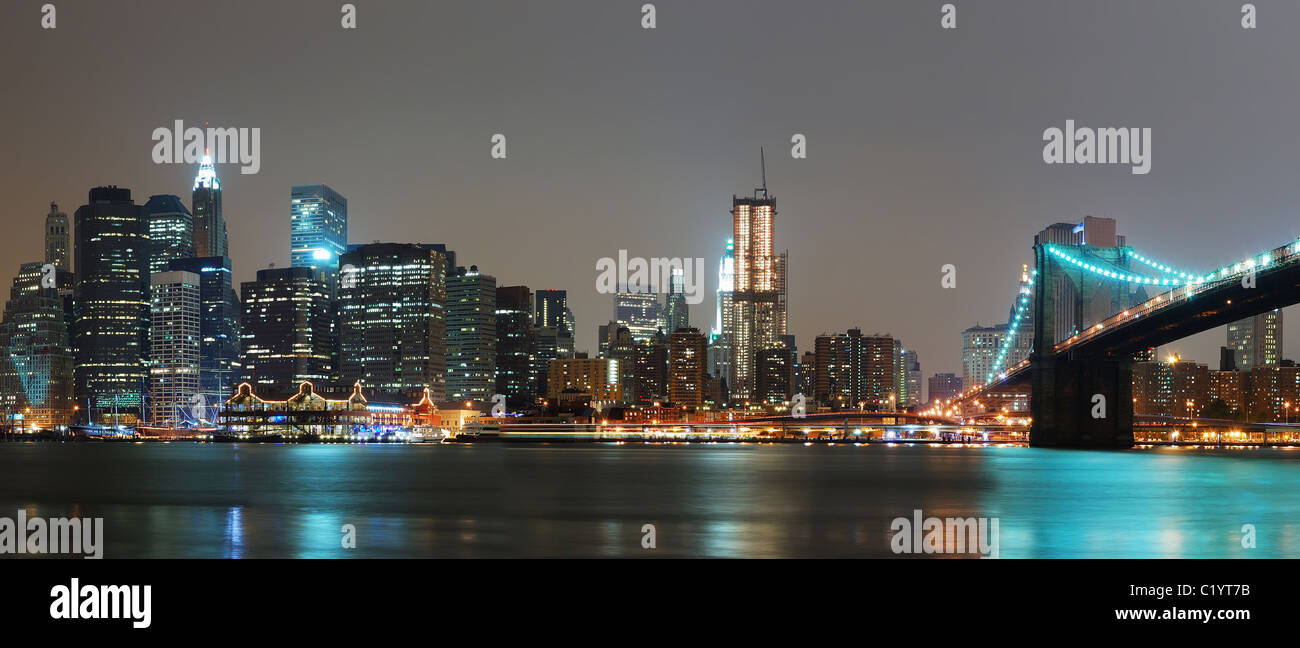 New York City night panorama with Brooklyn Bridge over East River ...
