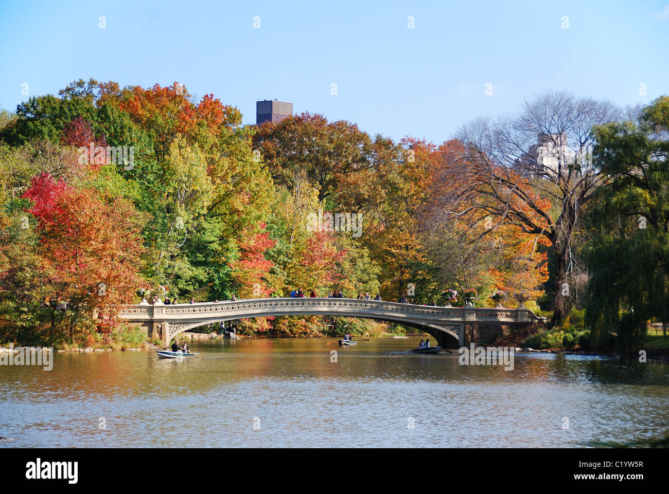 New York City Central Park panorama view in Autumn with Manhattan skyscrapers and colorful trees with Rainbow Bridge over lake w Stock Photo