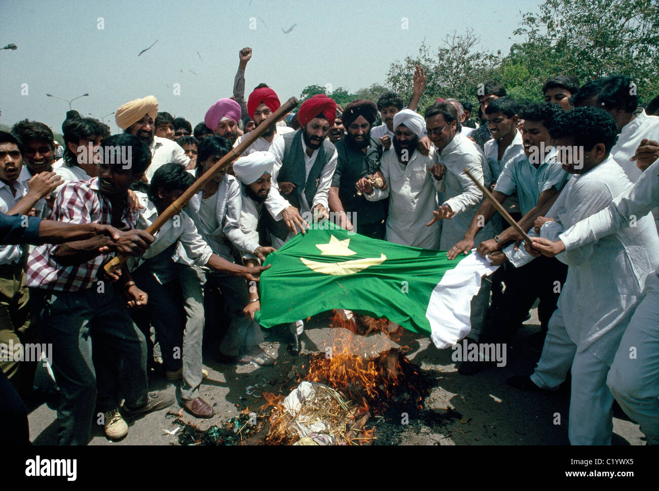 An effigy of  Pakistan's Prime Minister, Benazir Bhutto and a Pakistani flag is burned during a rally in New Delhi, India. Stock Photo