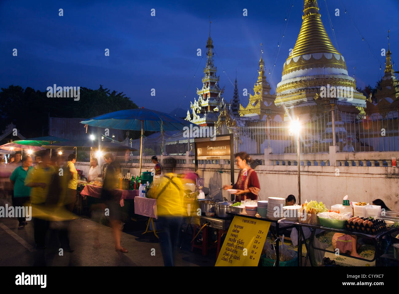 Night food market with the chedis of Wat Jong Kham and Wat Jong Klang in the background. Mae Hong Son, Mae Hong Son, Thailand Stock Photo